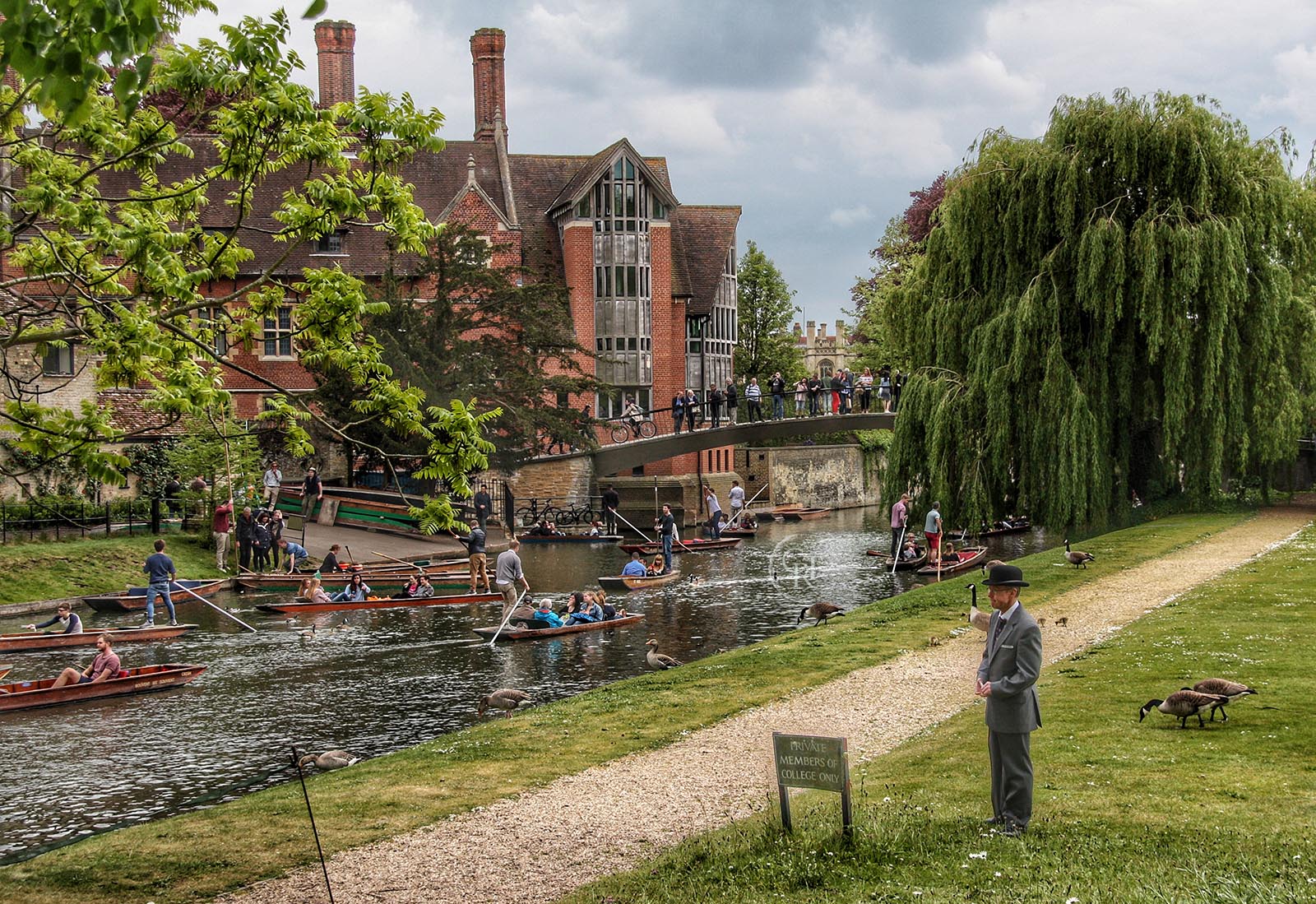 A college porter at Trinity watches the river Cam